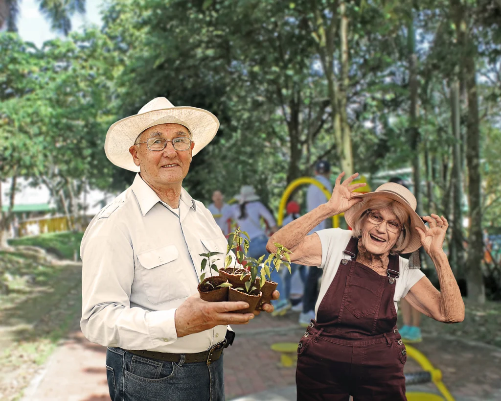 Pareja de personas de la tercera edad felices apunto de sembrar una planta en un parque
