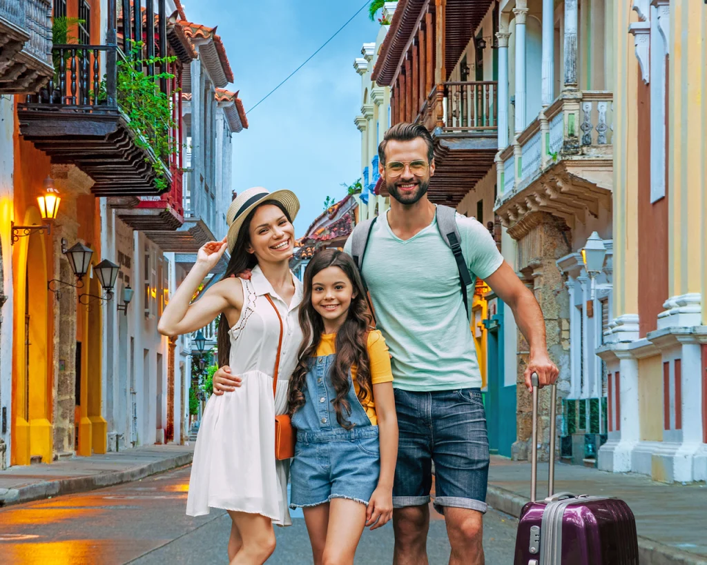 Papá, madre e hija con su maleta de viaje en calles de ciudad Cartagena