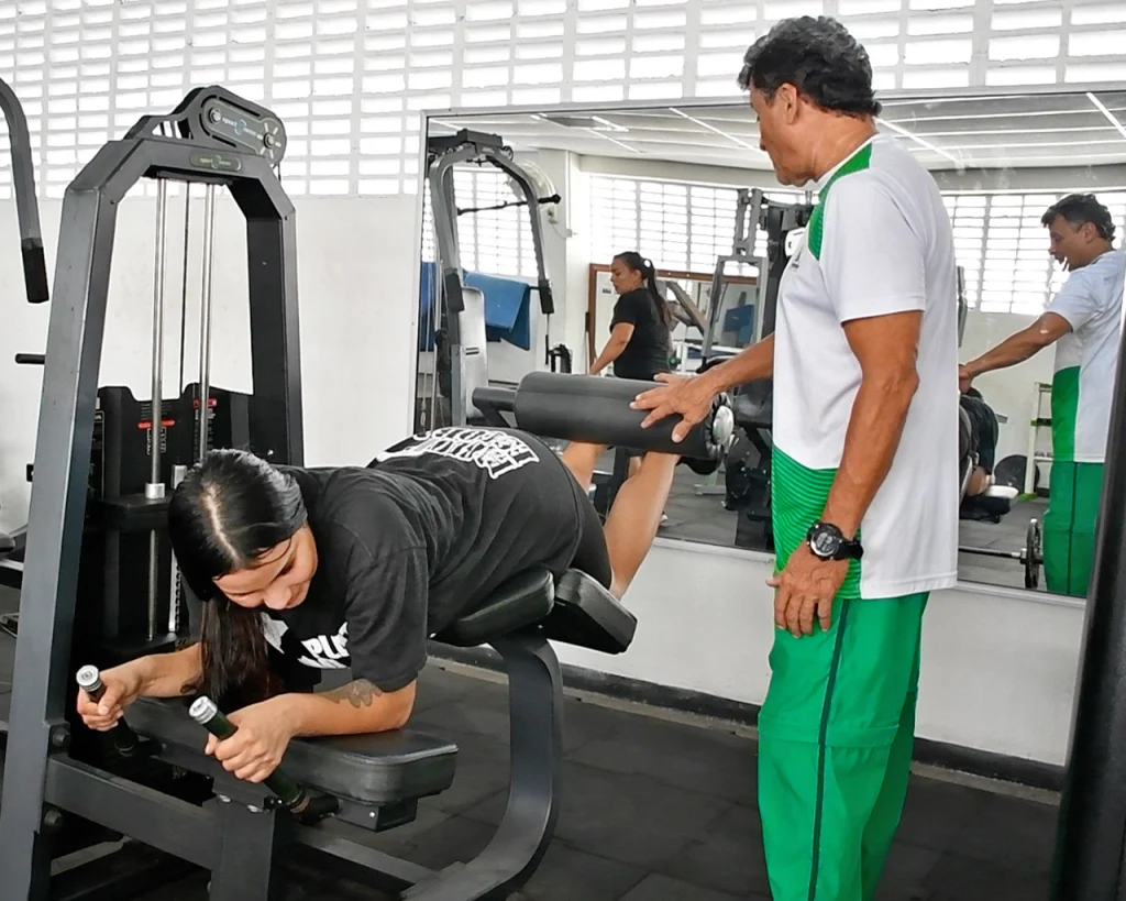 Instructor del gimnasio orientando ejercicios de usuaria del gimnasio