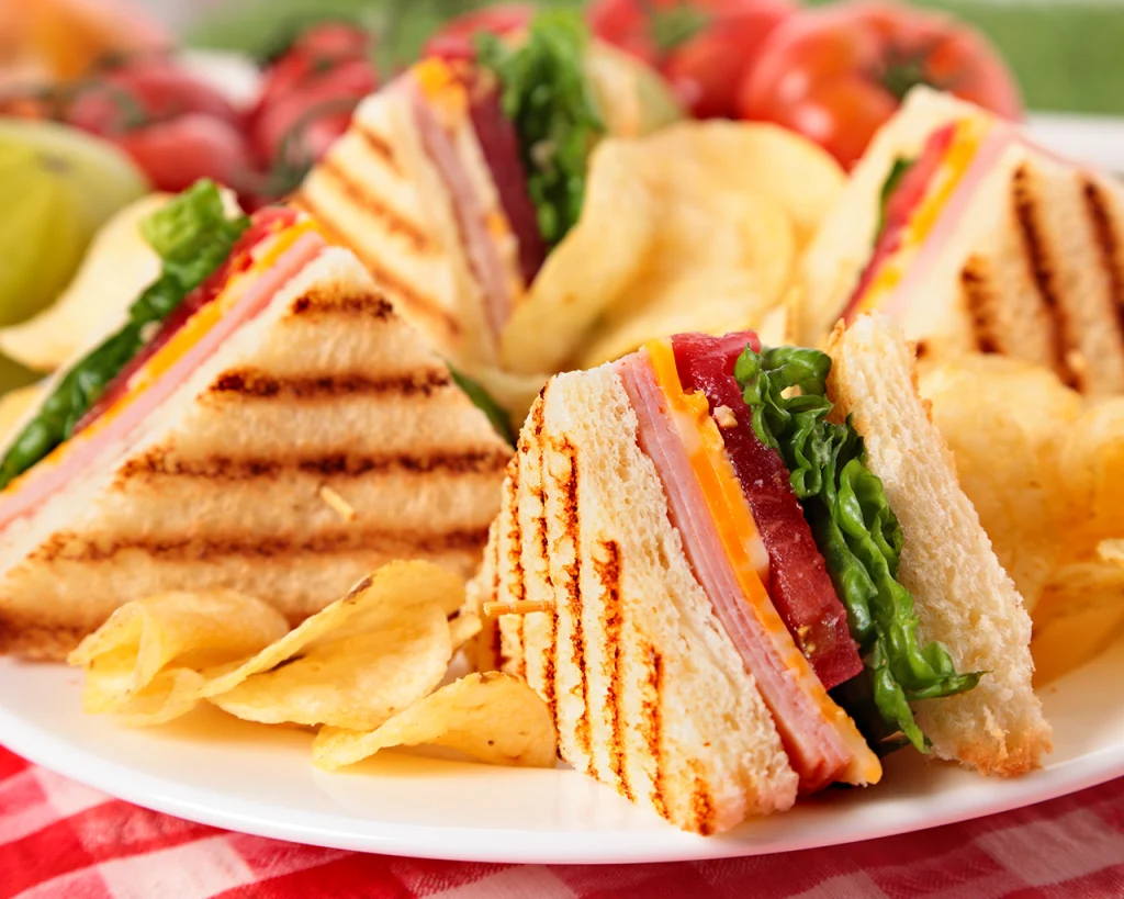 Sandwich club con jamón y queso en plato
