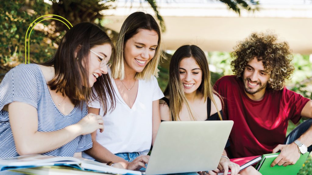 jóvenes estudiantes alegres viendo computador portatil