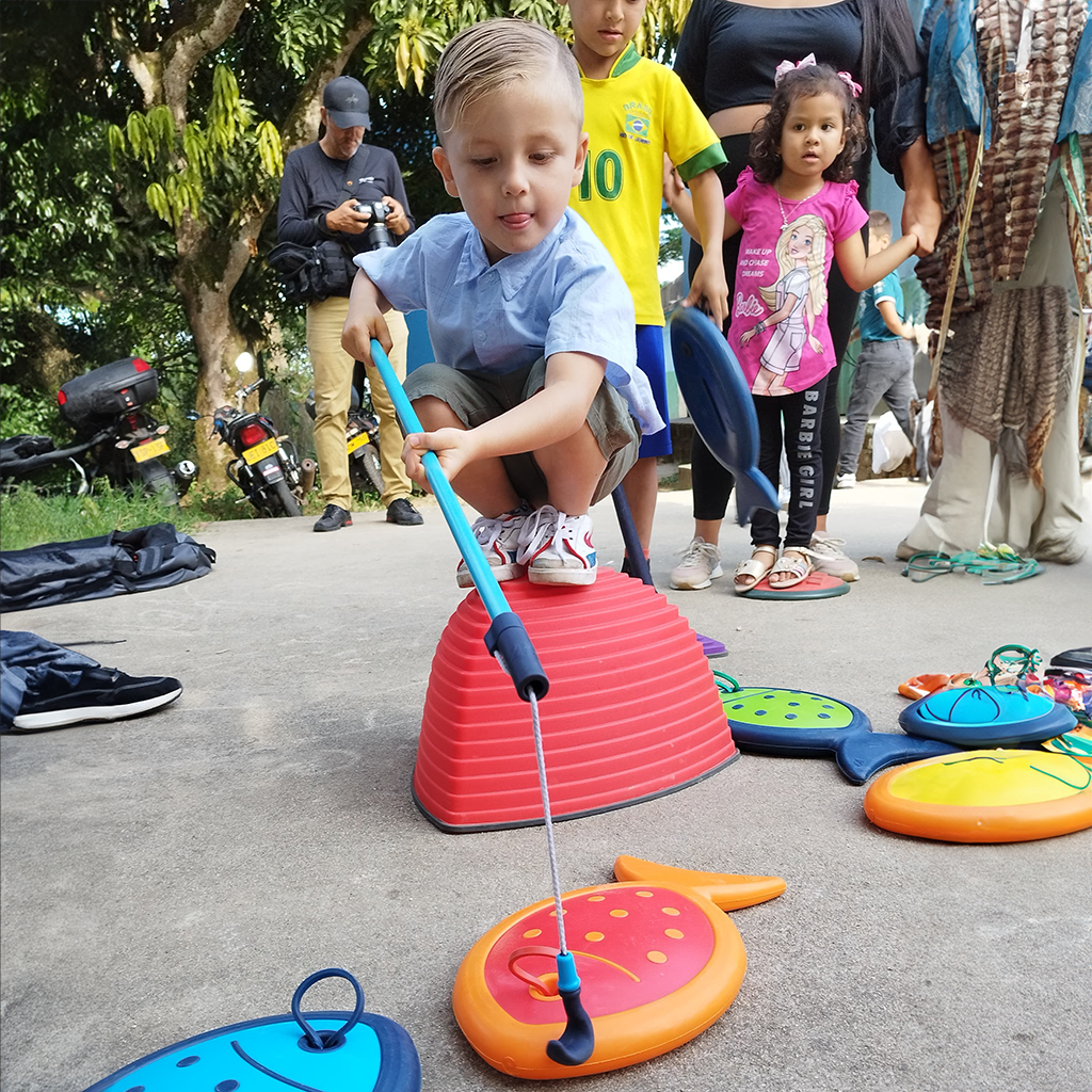 Niño pescando haciendo recreación pedagógica con juguetes de pesca