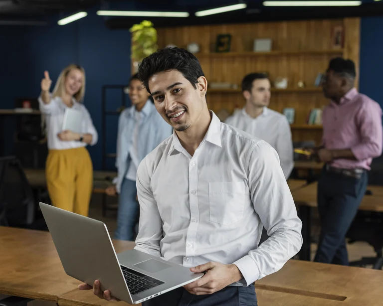 Hombre sonriente en el trabajo sosteniendo portátil