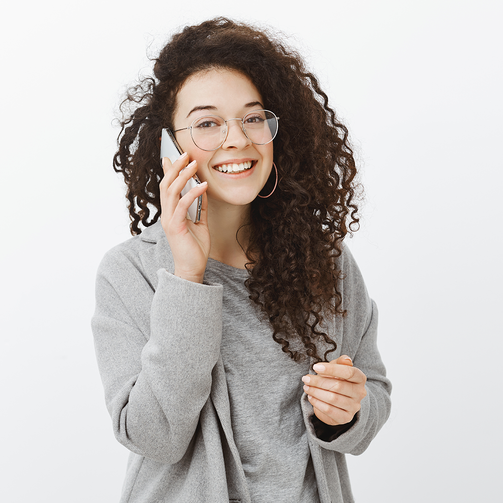 Mujer de cabello rizado atendiendo llamada por celular